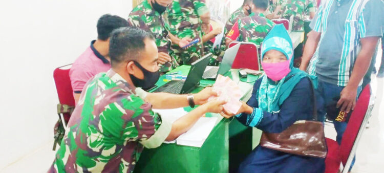 TERIMA— Seorang warga terlihat menerima dana bantuan yang diserahkan oleh anggota Kodim 0319/Mentawai.