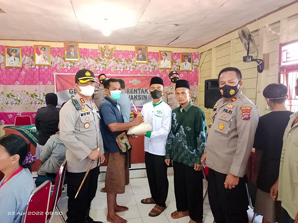 Bekerjasama dengan Kemenag, Polres Kepulauan Mentawai Gelar Vaksin Booster 1 SERAHKAN SEMBAKO—Kapolres Mentawai, AKBP Mu’at serahkan bantuan sembako kepada warga yang sudah divaskin .