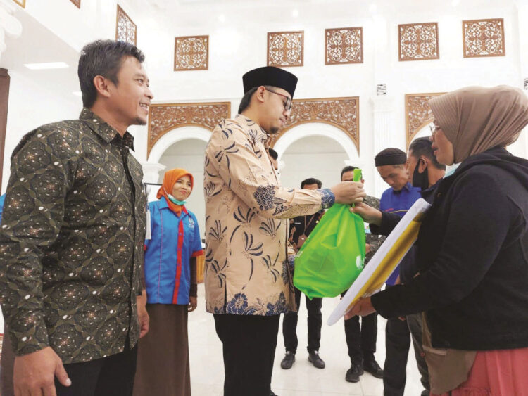 SIMBOLIS— Wali Kota Erman Safar bersama kepala BPJS menyerahkan bantuan sembako secara simbolis kepada buruh yang ada di Kota Bukittinggi.