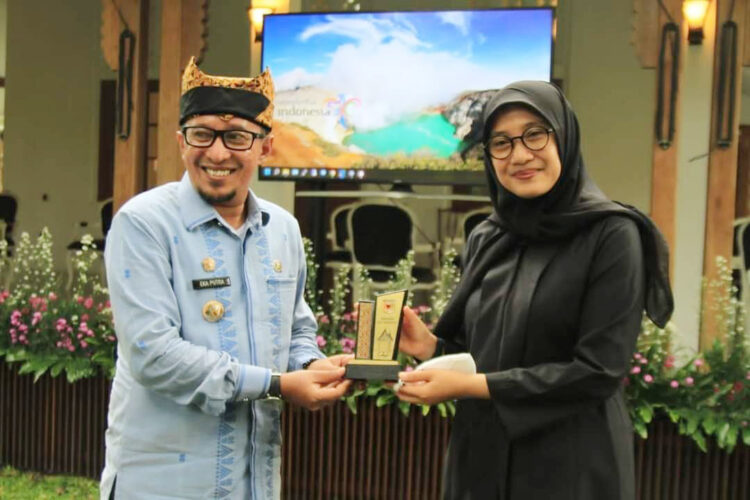 SERAHKAN CENDERA MATA— Bupati Tanahdatar Eka Putra serahkan cendera mata.