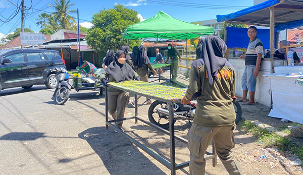 DIBONGKAR— Praja wanita Satpol PP Padang membongkar lapak-lapak dan tenda milik PKL di Jalan A Yani, Rabu (11/5). Lapak milik pedagang tersebut terpaksa dibongkar, karena didirikan di atas trotoar dan sengaja ditinggal usai berjualan pada malam hari.