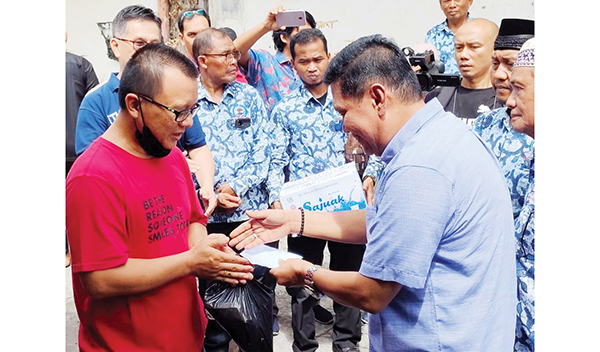 SERAHKAN BANTUAN— Ketua DPD LPM Kota Padang Irwan Basir Dt. Rajo Alam menyerahkan bantuan untuk keluarga korban kebakaran di jalan Pasar Baru Kelurahan Kampung Jao, Kecamatan Padang Barat, Jumat (27/5).