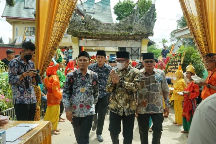 HADIRI MUBES— Bupati Tanahdatar Eka Putra didampingi anggota DPRD Adri Jinil berjalan menuju kursi VIP dalam acara Mubes X Simawang, Kamis (5/5).