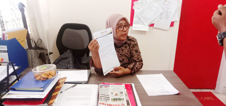 PERLIHATKAN DOKUMEN— Putri Deyesi Rizki memperlihatkan dokumen pencabutan surat kuasa pendampingan hukum terhadap tersangka dugaan korupsi dana hibah KONI Padang H Agus Suardi.