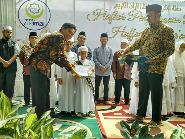 SERAHKAN—Ketua Yayasan Al Huffazh Kota Payakumbuh, Edi Kusmana menyerahkan piagam penghargaan kepada santri hafal quran di SD Al Huffazh Tanjuang Pauh.