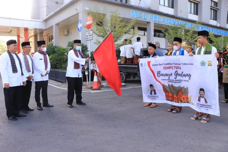 DILEPAS—Sekda didampingi asisten dan Kadisdik lepas arak-arakan siswa berpakaian adat memeriahkan peringatan Hardiknas.