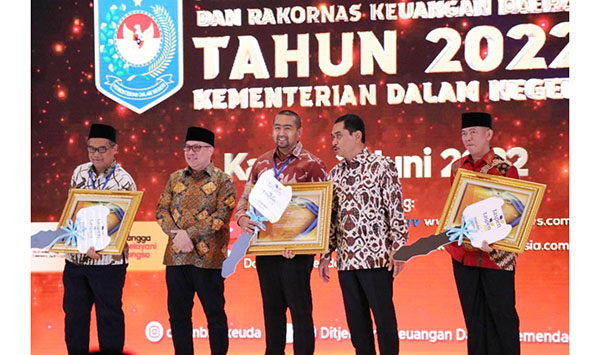 TERIMA PENGHARGAAN—Wagub Sumbar, Audy Joinaldy (tengah) menerima piagam penghargaan realisasi program Taspen dan satu unit ambulans secara simbolis dari Mendagri, Tito Karnavian pada acara Penganugerahan Realisasi APBD dan Rakornas Keuangan Daerah Tahun 2022, Kamis (2/6) di Jakarta Selatan.