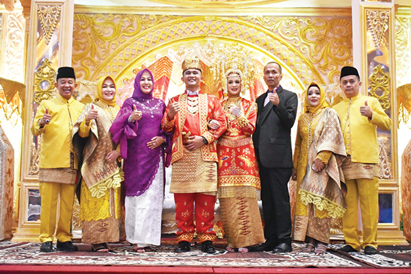 Beny Saswin Nasrun dan Hj. Asrinda Baminantu 1 Pasangan penganten Avif Mulya Pratama dengan Namira Putri Irawan foto bersama dengan Asrizal Ketua Fraksi DPRD Kota Padang bersama istri Eva di dampingi kedua orang tua pasangan penganten di pelaminan.