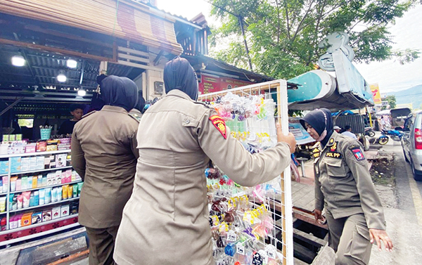 Pedagang di jalan raya Lubuk Begalung masih Bandel, Barang Dagangan Diletakkan di Trotoar 1 PENERTIBAN— Tim Praja Wanita Satpol PP Kota Padang melakukan penertiban terhadap pedagang yang memanfaatkan badan jalan untuk meletakkan papan iklan dan barang dagangan, di jalan raya Lubukbegalung, Senin (27/6).