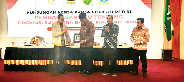 SERAHKAN CENDERA MATA—Ketua Komisi II DPR RI, Ahmad Doli Kurnia Tandjung menyerahkan cenderamata kepada Gubernur Sumbar, Mahyeldi Ansharullah saat Kunker Panja Komisi II DPR RI terkait pembahasan RUU tentang Provinsi Sumbar, Riau dan Jambi. Kamis (16/6) di Auditorium Gubernuran Sumbar.