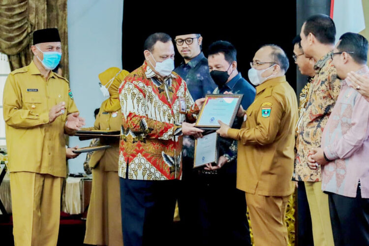 SERAHKAN—Ketua KPK RI, Firli Bahuri disaksikan Gubernur Sumbar, Mahyeldi Ansharullah menyerahkan penghargaan peringkat 3 MCP kepada Pemprov Sumbar yang diterima oleh Sekdaprov Sumbar, Hansastri.
