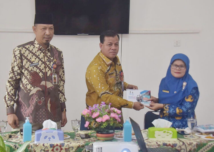KUNJUNGAN— Kepala Disdukcapil Maini,M.M serahkan brosur tentang Padangpanjang.