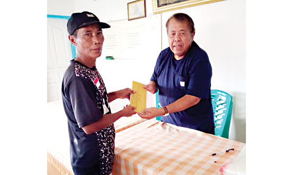 SERAHKAN BANTUAN— Ketua Koperbam Chandra menyerahkan bantuan kepada Mulyanto, yang rumahnya ambruk akibat longsor, kemarin.