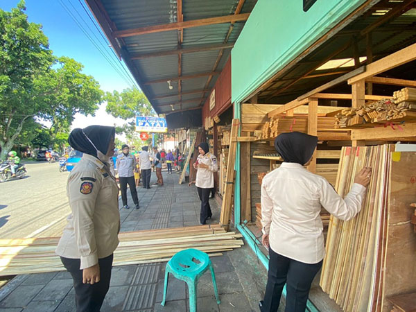 KUASAI TROTOAR— Petugas Satpol PP menegur sejumlah pemilik toko yang memakai trotoar hingga bahu jalan untuk meletakkan barang dagangannya, Jumat (24/6). Kebiasaan pemilik toko menaruh barang dagangan di trotoar ini banyak dijumpai di Kota Padang.