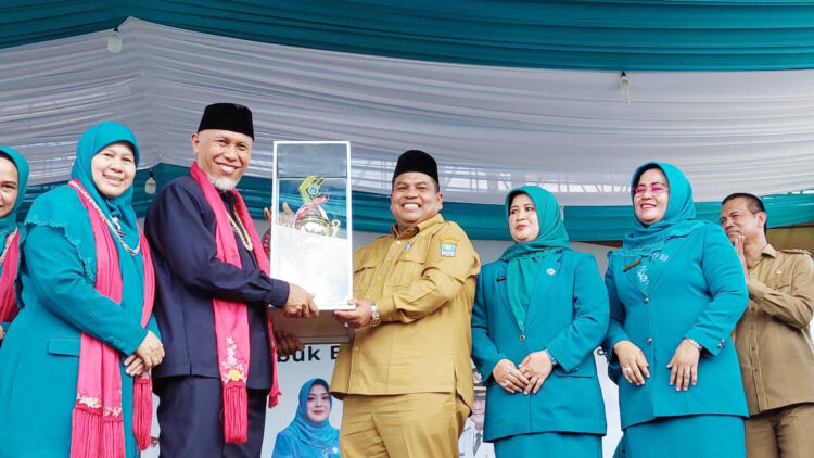 SERAHKAN PIALA— Gubernur Sumatera Barat Mahyeldi, didampingi Ketua Umum TP-PKK Provinsi Sumatera Barat Umi Harnely Mahyeldii, serahkan piala juara umum pemenang jambore kader PKK berprestasi Ke XIX tingkat Sumatera Barat tahun 2022, yang diterima Bupati Padangpariaman Suhatri Bur didampingi Ketua TP PKK Yusrita Suhatri Bur.