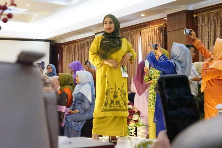 PERAGAKAN— Ny Lise Eka Putra saat memperagakan baju kuruang basiba.