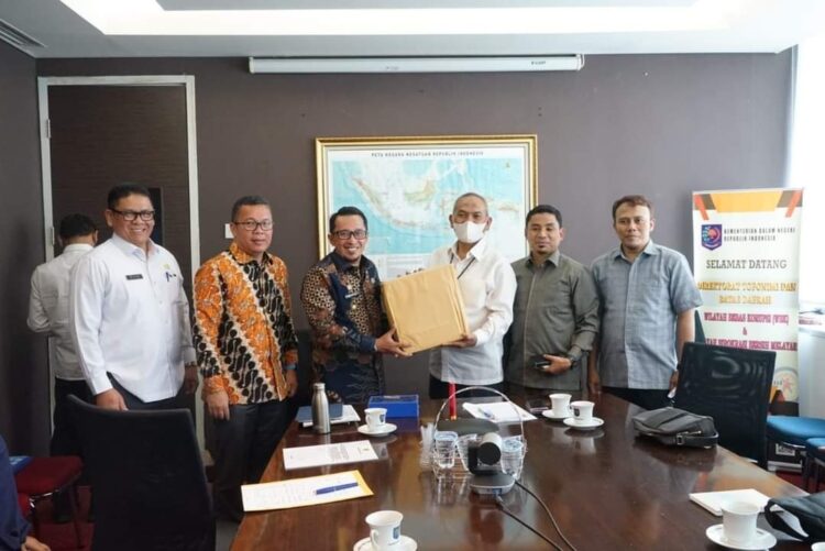 SERAHKAN CENDERA MATA— Bupati Eka Putra serahkan cendera mata kepada  Direktur Toponimi dan Batas Daerah Dirjen Bina Administrasi Kewilayahan Kemendagri Sugiarto.