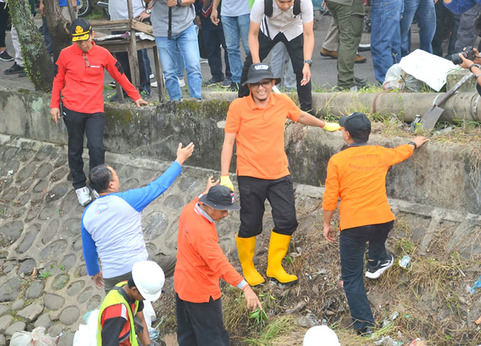 GOTONG ROYONG— Wali Kota Padang, Hendri Septa gotong royong bersama warga memunguti sampah di sepanjang banda bakali Jalan Perintis Kemerdekaan, Kelurahan Sawahan Timur, Minggu (17/7).