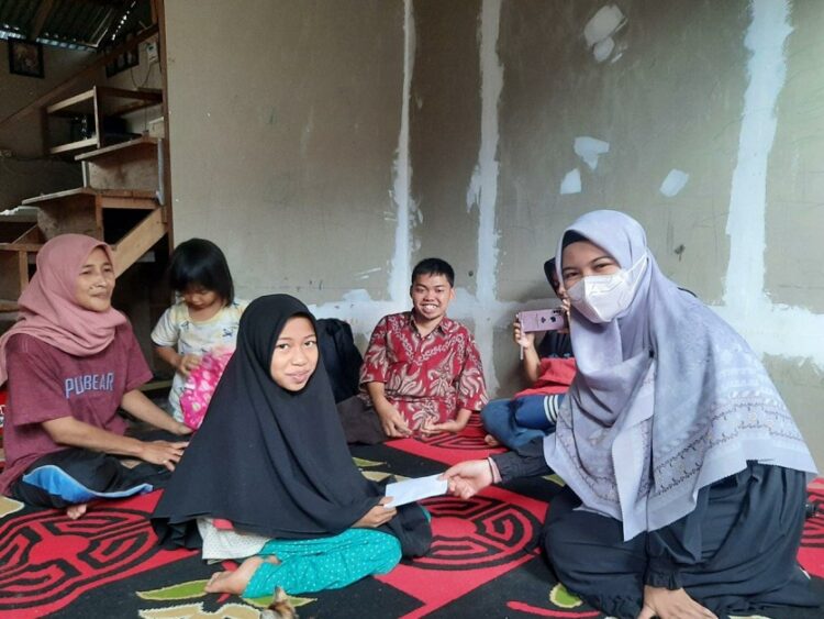 SERAHKAN BANTUAN—Mutiara saat didampingi orang tuanya, Defni usai menerima bantuan.