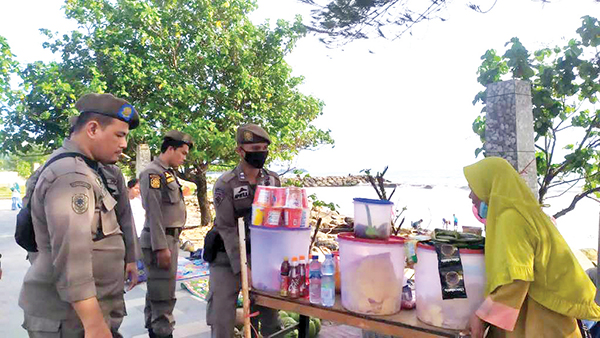 PENERTIBAN PEDAGANG PANTAI—  Tim gabungan Satpol PP, TNI dan Polri kembali melakukan penertiban terhadap PKL yang masih mencoba untuk berjualan di bibir Pantai Cimpago, Jumat (1/7).