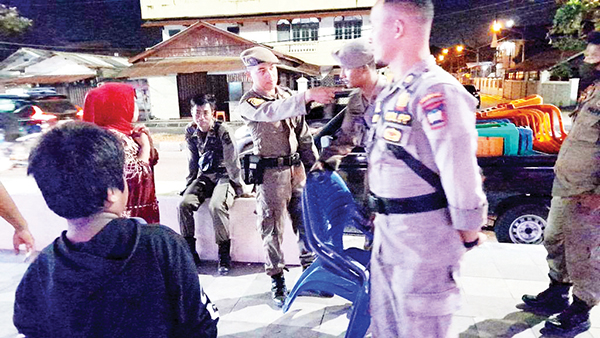 PENERTIBAN— Petugas Satpol PP mengambil puluhan kursi plastik PKL yang diletakkan di trotoar untuk memfasilitasi pembeli untuk menikmati makanan dan minuman, Minggu (10/7) sore, di kawasan Pantai Padang dan Jalan Gereja.