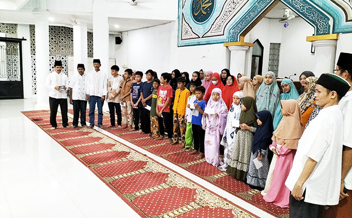 SANTUNAN PENDIDIKAN— Pengurus Masjid Al Fath Goba Seberang Padang menyerahkan santunan pendidikan untuk 35 anak yatim mulai dari tingkat SD dan SMP, Selasa (5/7).