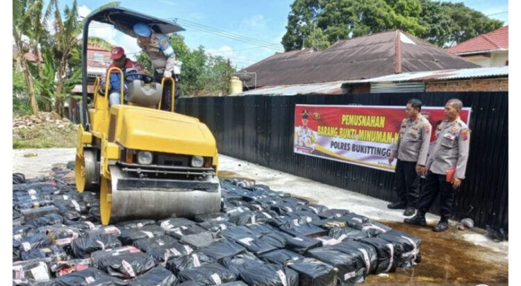 MIRAS-Puluhan botol miras yang didapat dari hasil penindakan di Jalan Raya Bukittinggi-Padang, Jorong Bangkaweh, Nagari Padang Luar, Kecamatan Banuhampu, dimusnahkan dengan cara dilindas