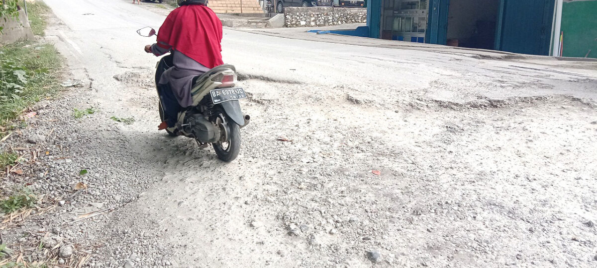 Ruas jalan Sapan yang patahannya tinggi sehingga pengendara roda dua memilih jalan ketepi untuk menghindari kecelakaan.