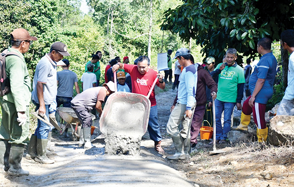 PENGECORAN JALAN— Tim Unit CSR PT Semen Padang turut berbaur bersama warga pada gotong-royong pengecoran jalan di Bukit Aua, Kelurahan Limau Manis, Kecamatan Pauh, yang digelar pada Minggu (7/8) lalu.