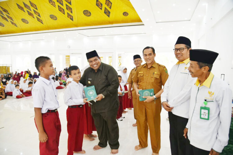 SERAHKAN—Bupati Padangpariaman Suhatri Bur saat penyerahan zakat untuk anak SD dan SMP di wilayannya.