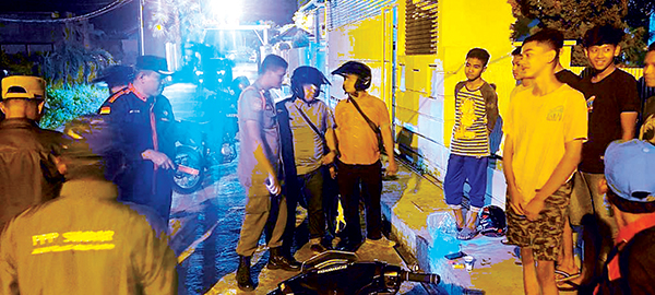 TERJARING RAZIA— Petugas Satpol PP Padang melakukan razia sejumlah remaja yang tengah nongkrong di trotoar kawasan Belanti, Kecamatan Padang Barat, Sabtu (30/7) dini hari WIB.