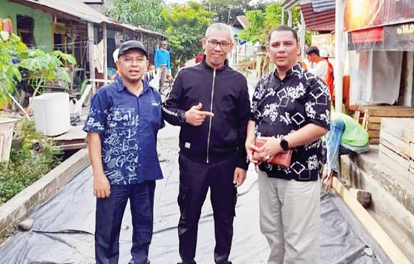 PENGECORAN JALAN— Anggota DPRD Padang dari Fraksi Gerindra Budi Syahrial meninjau langsung pengecoran jalan di RW VII Kelurahan Putus, Kecamatan Padang Barat, Rabu (3/8).