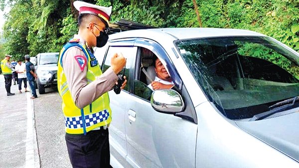 CEK KELENGKAPAN KENDARAAN— Kasubnit BM Satlantas Polresta Padang Ipda Fajril memberikan himbauan agar pengendara memakai sabuk pengaman ketika berkendara di kawasan Lubuk Paraku, Kelurahan Indarung, Kecamatan Lubuk Kilangan.