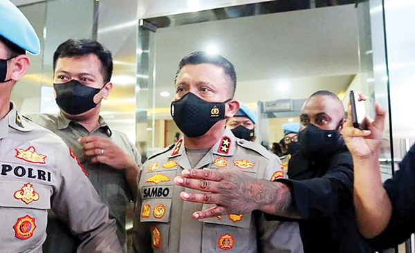 TATO—Terlihat seorang pria dengan tato di tangan kirinya mengawal Irjen Ferdy Sambo di Bareskrim Polri saat dimintai keterangannya sebagai saksi.