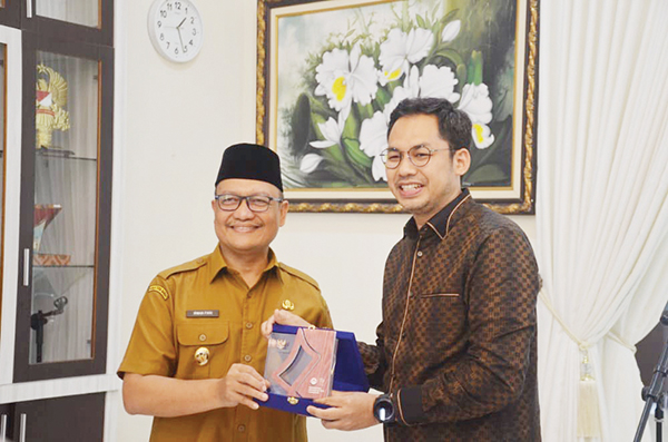CINDERAMATA— Wabup Agam menerima cinderamata dari Komisioner Lembaga Negara Komisi Penyiaran Indonesia (KPI) Yuliandre Darwis saat melakukan kunjungan ke Kabupaten Agam, Selasa (2/8).