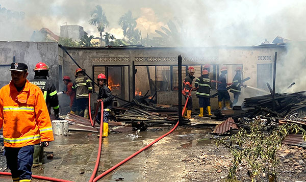 KEBAKARAN— Petugas Damkar berupaya memadamkan api yang membakar dua rumah semi permanen di Kelurahan Ganting Parak Gadang, Kecamatan Padang Timur.