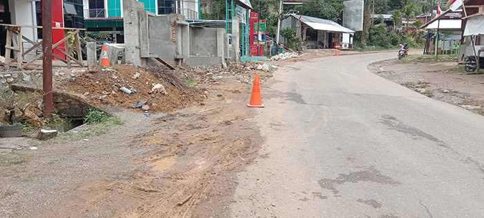 BELUM DICOR—Bekas galian pipa PDAM Sawahlunto yang belum dicor di depan Puskesmas Sungai Durian Kecamatan Barangin, terlihat tumpukan material, serta masih penutupan tanah yang belum dicor.