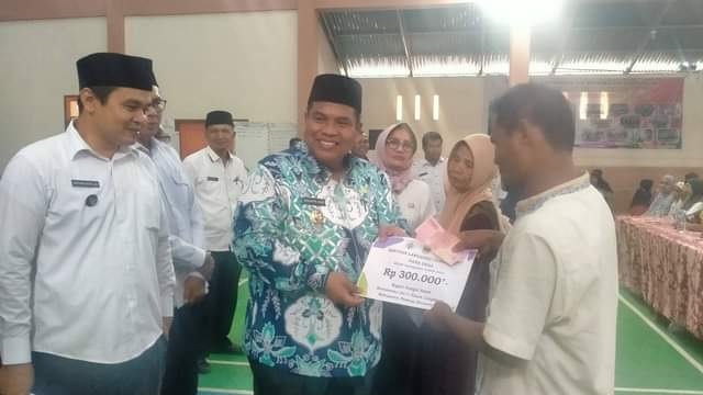 SERAHKAN BLT—Suhatri Bur saat penyerahan BLT kepada perwakilan warga.