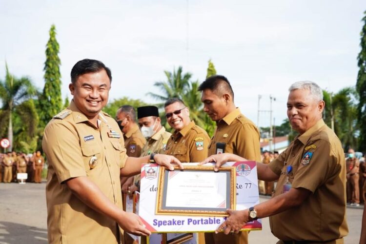 SERAHKAN—Bupati Sutan Riska menyerahkan penghargaan kepada OPD berprestasi tingkat OPD se Dharmasraya.