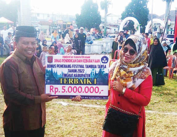 TERIMA HADIAH— Salah satu pemenang festival Tambua Tansa tingkat Agam-Bukittinggi yang digelar Sabtu dan Minggu (3-4/9), di eks lapangan terbang Gadut menerima hadiah yang diserahkan langsung oleh Kepala Disdikbud Agam, Isra, Senin (5/9).