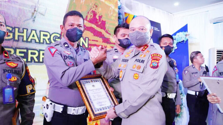 SERAHKAN PERNGHARGAAN— Kapolda Sumbar, Irjen Pol Teddy Minahasa, menyerahkan penghargaan kepada Aipda Doni lham yang merupakan personel Ditlantas Polda Sumbar.