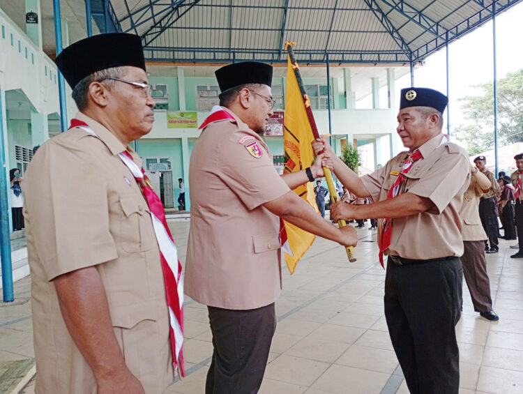 TERIMA—Ketua Kontingen Pramuka Tanah Datar Sabrimen menerima bendera kontingen dari Wabup Richi Apriana.