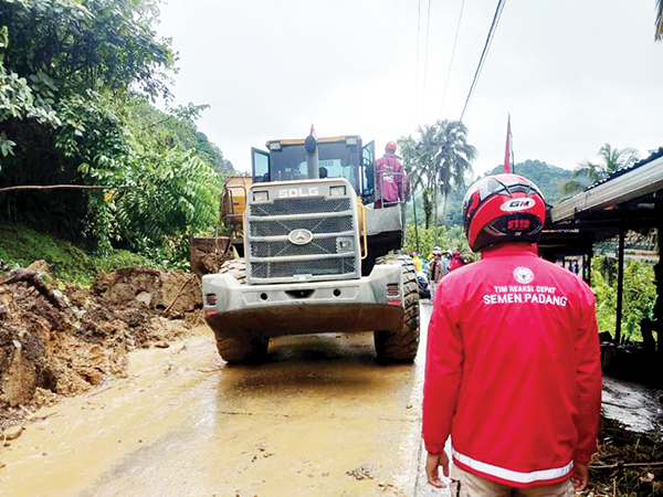 BERSIHKAN MATERIAL LONGSOR— Tim Reaksi Cepat (TRC)  Semen Padang ikut membersihkan material longsor di kawasan Aia Baliang, Sabtu (20/8). Data dari BPBD Kota Padang, terdapat sebanyak 5 titik longsor terjadi di kawasan Sitinjau Lauik akibat hujan deras yang terjadi.