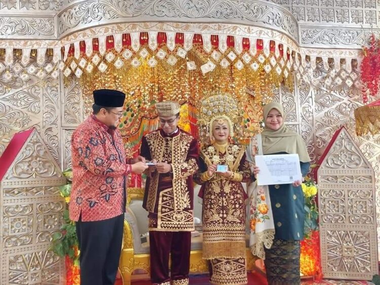 Wagub Tanah Datar Berikan “Salam Kebahagian” pada Pasangan Menmpelai 1 SERAHKAN—Wabup Richi Apriana serahkan Salam Kebahagiaan (Setelah Akad Langsung Menerima KTP El, Buku Nikah dan Kartu Keluarga Insya Allah Amanah).