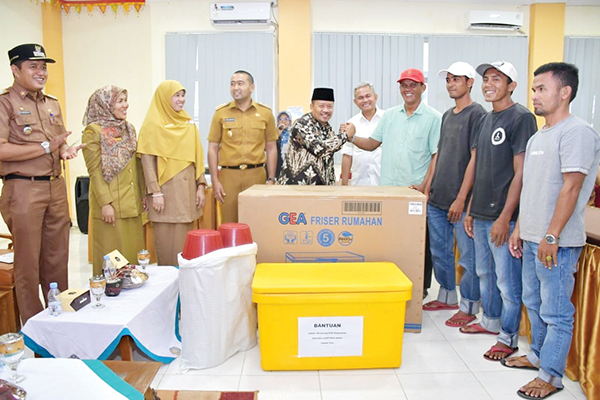 SERAHKAN BANTUAN— Bupati Agam menyerahkan bantuan dari Wagub Sumbar Audy Joinaldy pada koperasi nelayan dan Kelompok Pengolahan Pemasaran (Poklahsar) perikanan, di Kecamatan Tanjung Mutiara, Rabu (21/9).