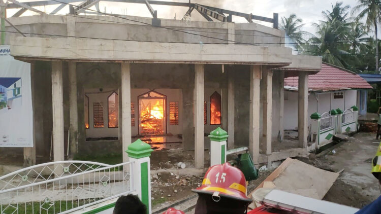 KEBAKARAN— Petugas Damkar melakukan penyemprotan air untuk memadamkan api yang membakar Masjid Darul Muhajirin.