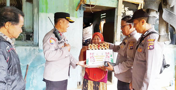 BAGI SEMBAKO— Terlihat Kasat Binmas Polresta Padang Kompol Darto bersama personel lainnya membagikan sembako kepada warga yang terdampak penyesuaian harga BBM, Selasa (13/2).