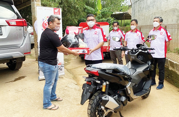 LAYANAN PENGANTARAN— Manager Customer Service HC3 AHM, Mosha Yulian Joyosuyono bersama dengan manajemen Astra Motor Jakarta memberikan layanan pengantaran unit ke rumah konsumen setia sepeda motor Honda di momen perayaan Harpelnas.