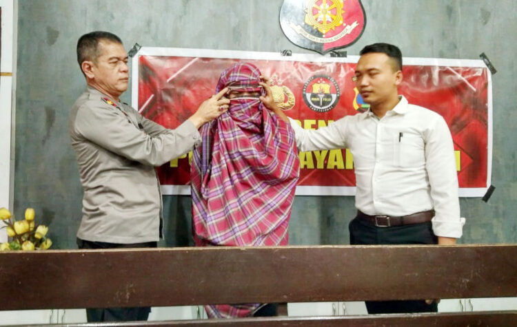 Jadi Ninja, Karyawan Toko Beras Embat Uang Majikan di Kota Payakumbuh, Dipakai Beli Chip Higgs Domino dan Bayar Utang 1 CURI UANG— Wakapolres Payakumbuh Kompol Russirwan bersama Reskrim Iptu Alva Zakya Akbar memperagakan pelaku WK memakai kain sarung saat mencuri uang milik majikannya.