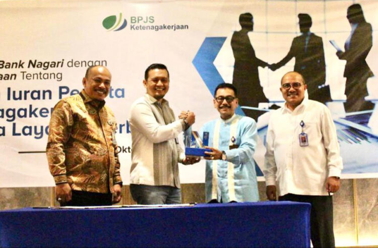 KERJA SAMA— Dirut Bank Nagari Muhamad Irsyad memberikan cenderamata kepada Direktur Keuangan BPJS Ketenagakerjaan Asep Rahmat Suwandha, didampingi Direktur Keuangan Bank Nagari Sania Putra, Jumat (14/10).